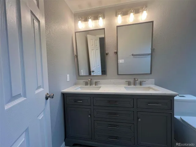 a bathroom with a double vanity sink and a mirror