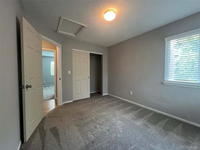 an empty room with windows and closet