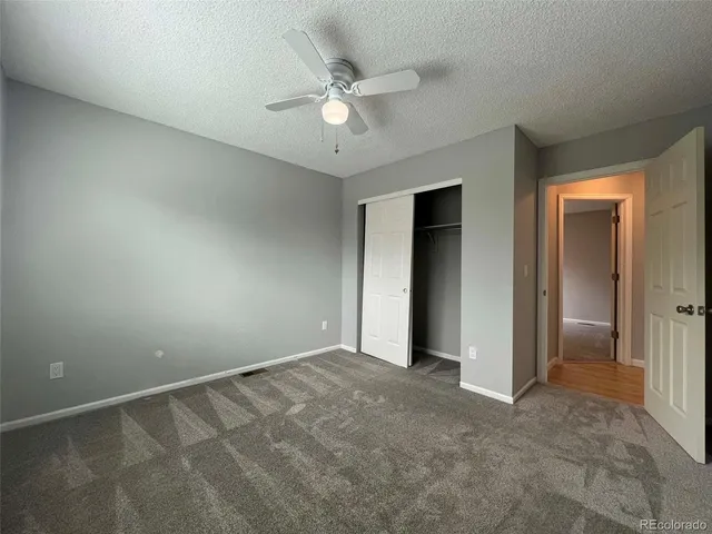 an empty room with closet and ceiling fan