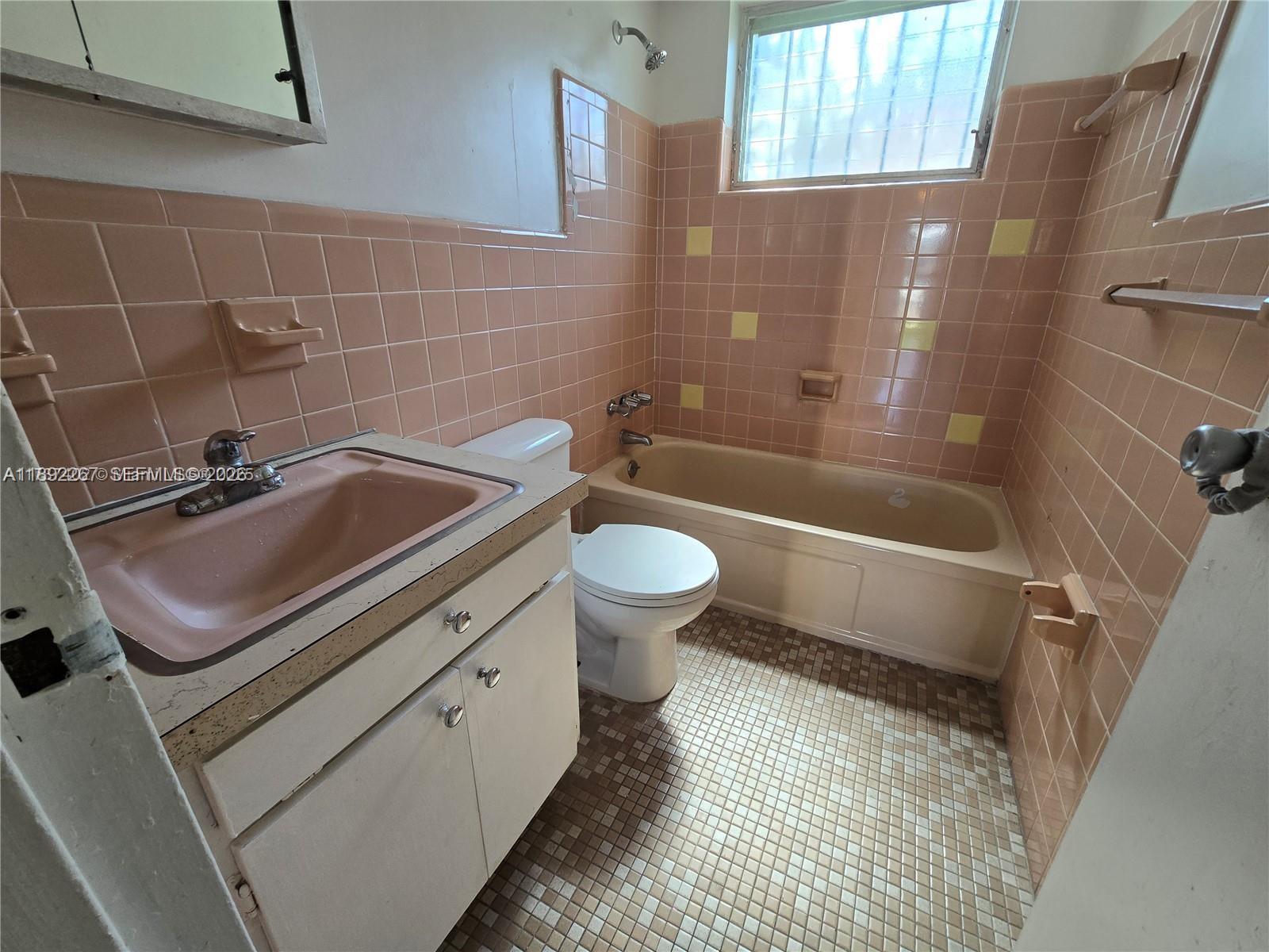 70 Northwest 77th Street, Unit 11 Miami, FL 33150 - Photo 4 of 16 a bathroom with a sink a toilet and shower