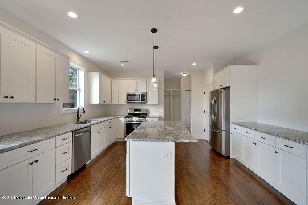 113 Lanyard Road Manahawkin, NJ 08050 - Photo 24 of 71 a kitchen with stainless steel appliances kitchen island granite countertop a refrigerator a sink dishwasher a stove and white cabinets with wooden floor