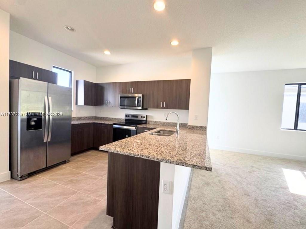 5277 Marano Drive Ave Maria, FL 34142 - Photo 4 of 23 a kitchen with stainless steel appliances granite countertop a refrigerator a sink a stove and oven