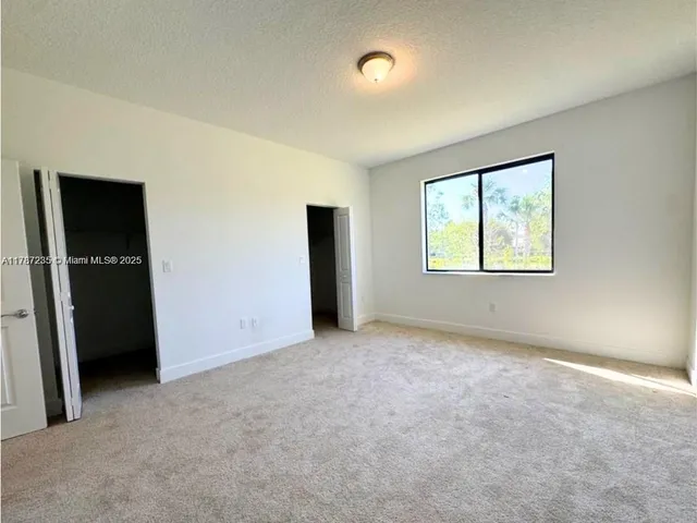 an empty room with closet and windows