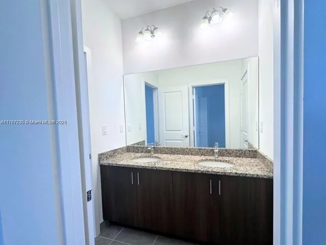a bathroom with a granite countertop sink and a mirror
