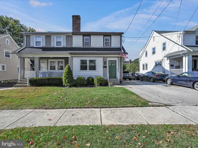 a front view of a house with a yard and potted plants