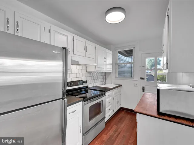 a kitchen with granite countertop a stove sink and refrigerator