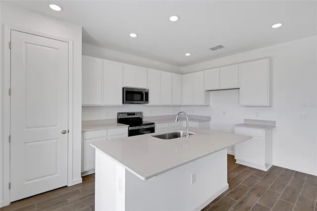 a kitchen with appliances a sink and cabinets
