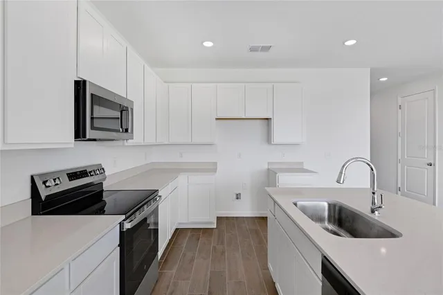 a kitchen with a sink cabinets and stainless steel appliances