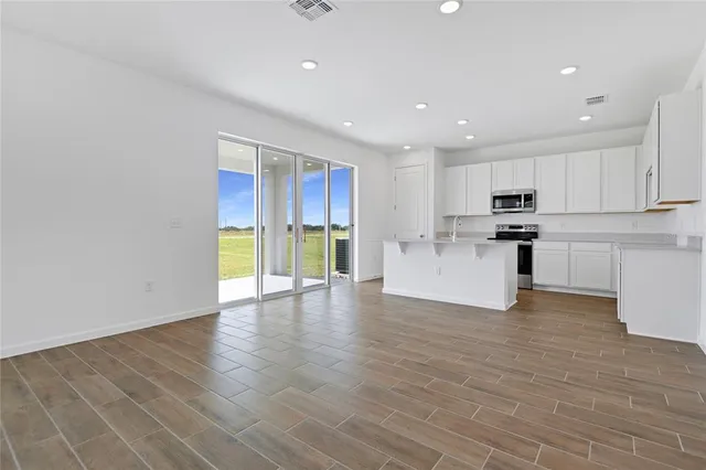 a view of a kitchen with a sink a refrigerator and window