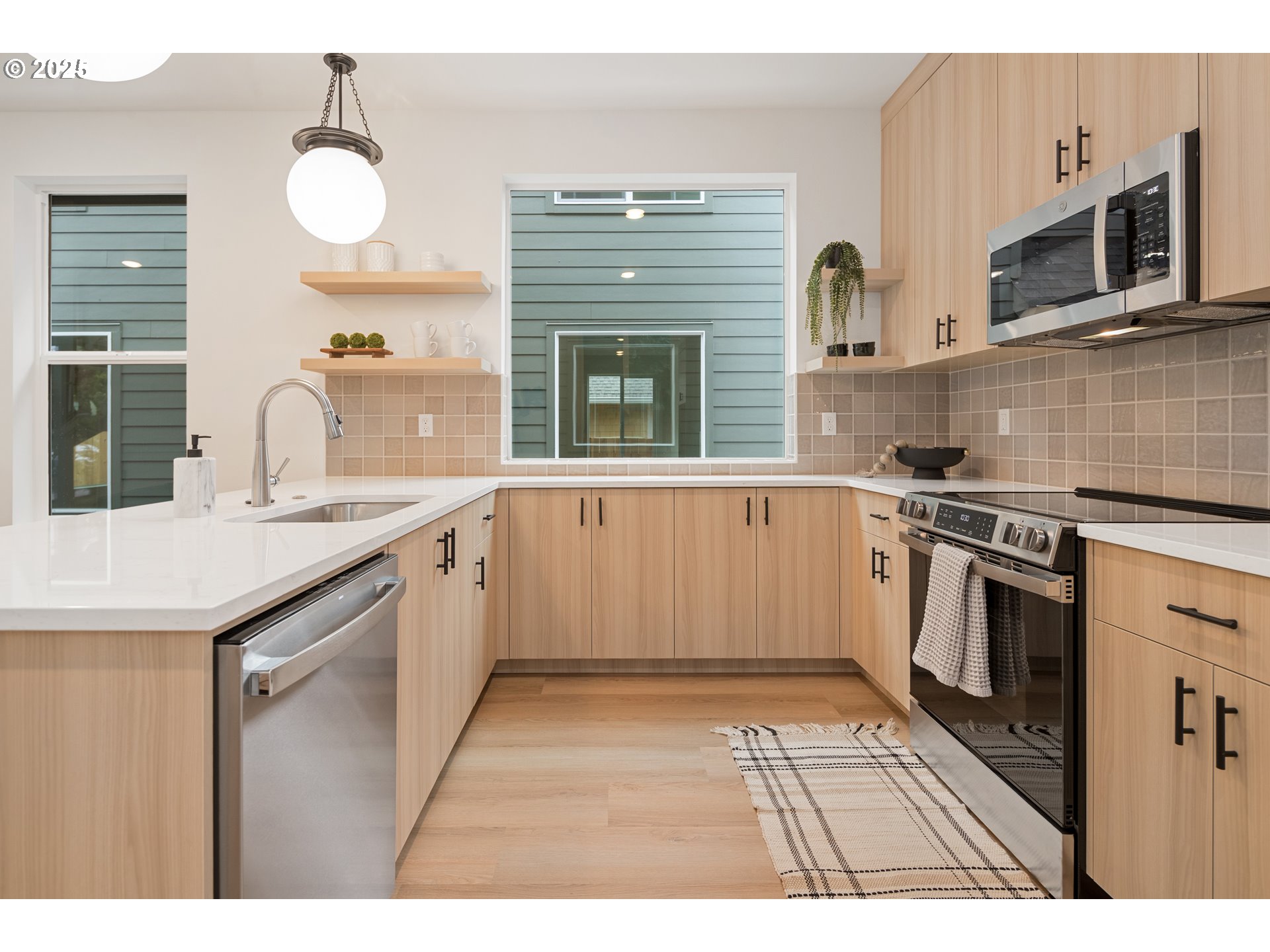 4031 Southeast Tibbetts Street Portland, OR 97202 - Photo 5 of 21 a kitchen with stainless steel appliances granite countertop a stove a sink and a microwave