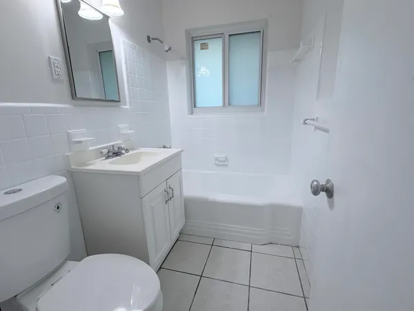 a bathroom with a bathtub sink vanity and mirror