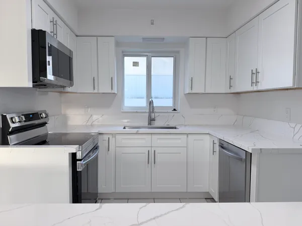 a kitchen with stainless steel appliances granite countertop a sink stove and microwave
