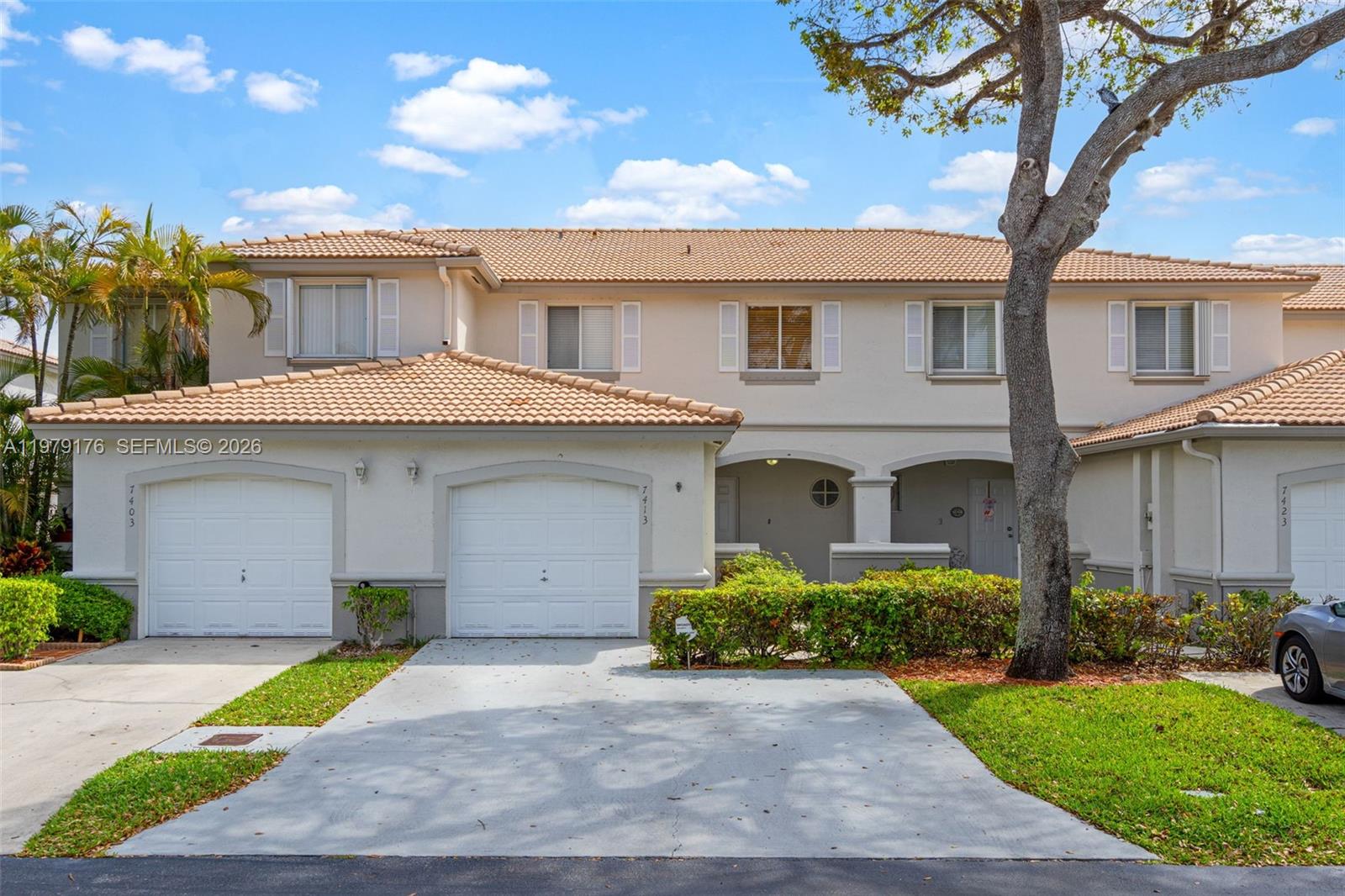 7413 Southwest 162nd Path Miami, FL 33193 - Photo 1 of 44 a front view of a house with a garden and a tree