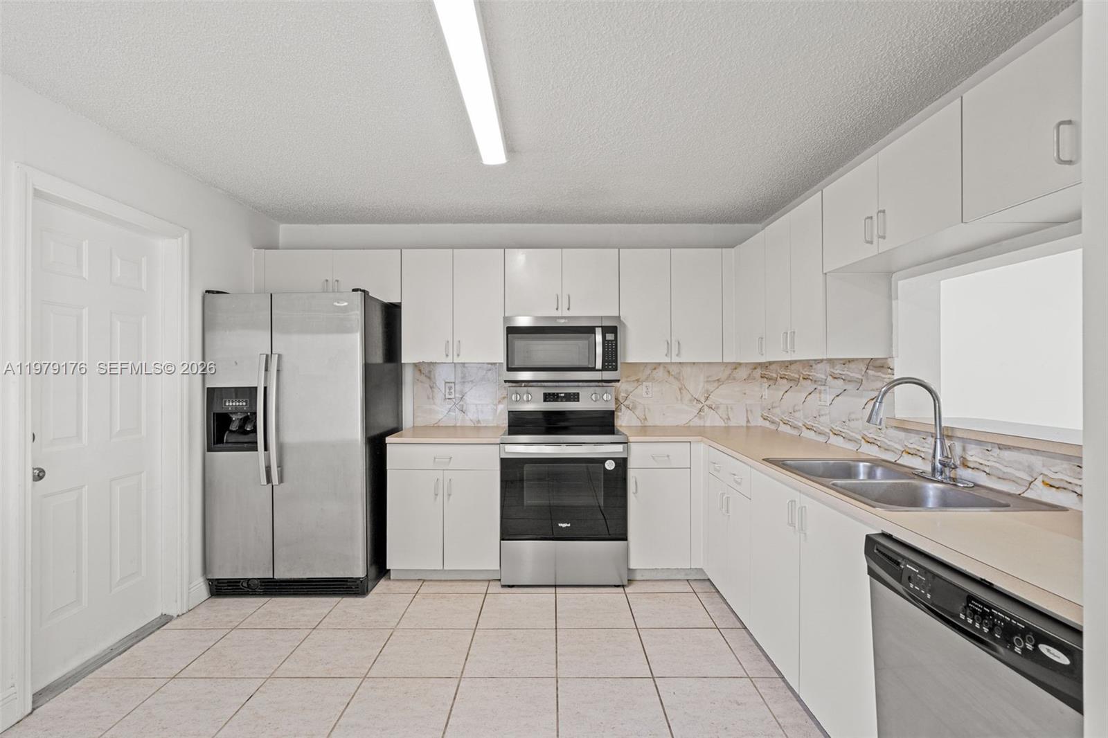 7413 Southwest 162nd Path Miami, FL 33193 - Photo 15 of 44 a kitchen with stainless steel appliances granite countertop a refrigerator sink and stove
