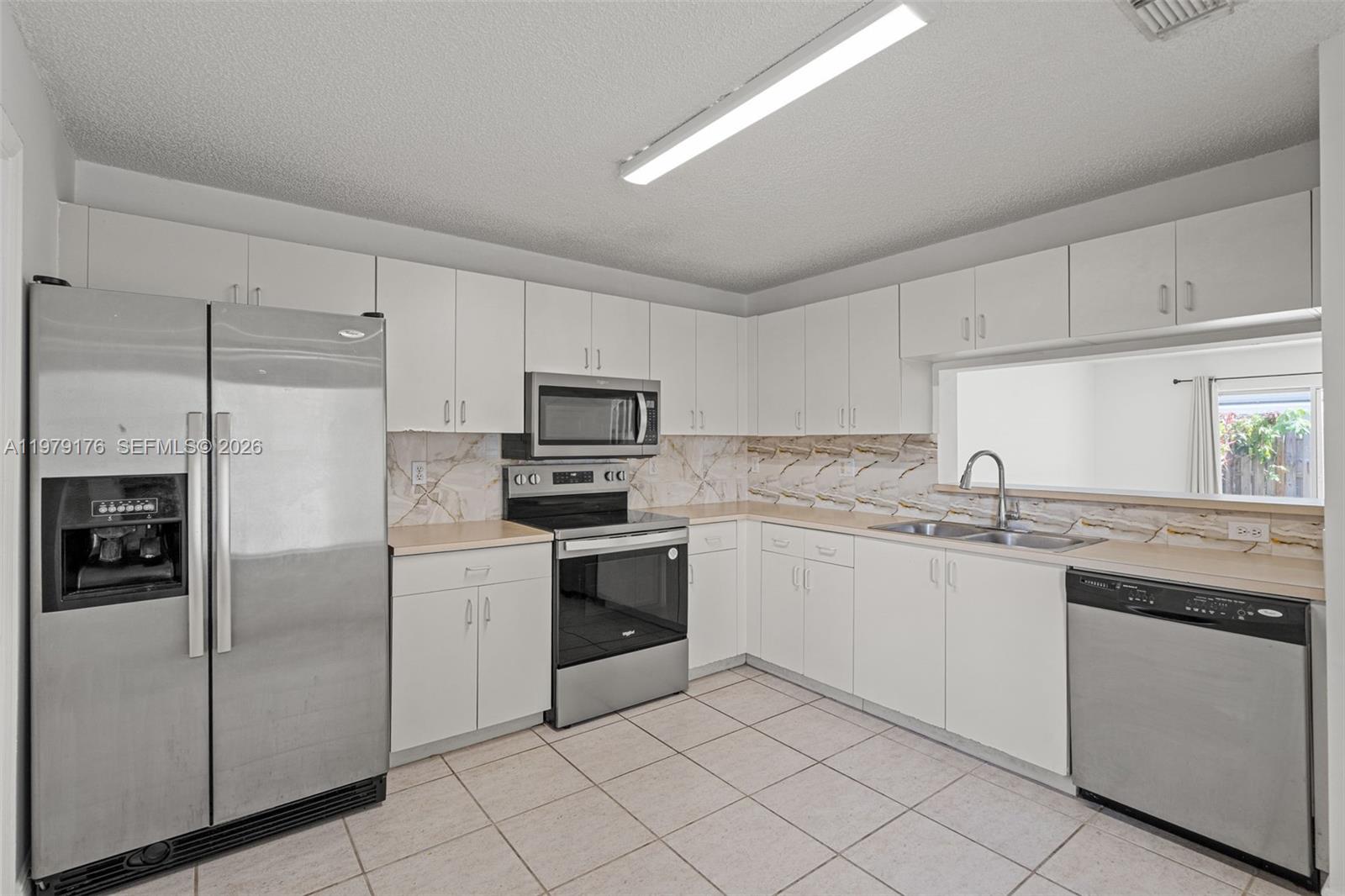 7413 Southwest 162nd Path Miami, FL 33193 - Photo 16 of 44 a kitchen with appliances cabinets and furniture