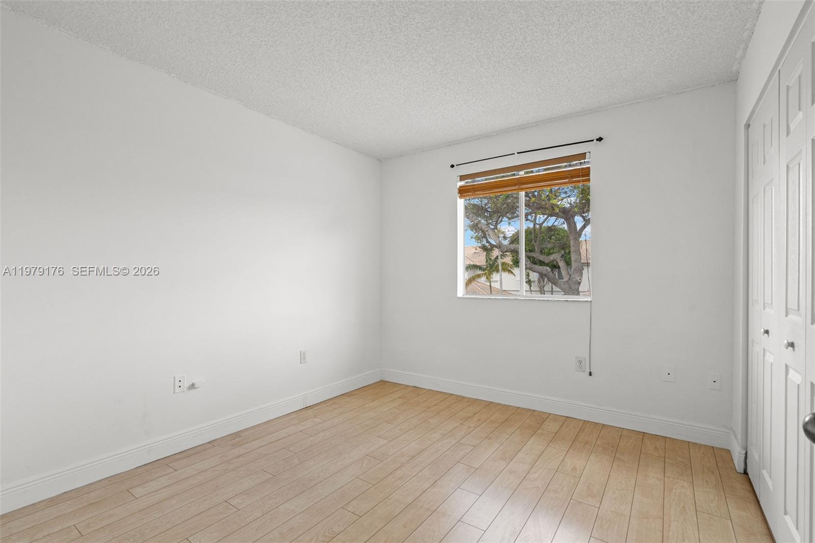 7413 Southwest 162nd Path Miami, FL 33193 - Photo 24 of 44 an empty room with wooden floor and windows