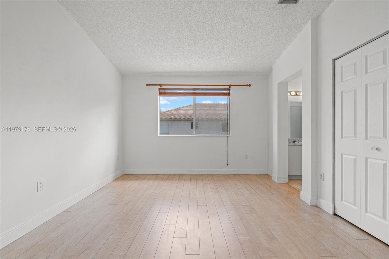 7413 Southwest 162nd Path Miami, FL 33193 - Photo 30 of 44 an empty room with wooden floor and windows