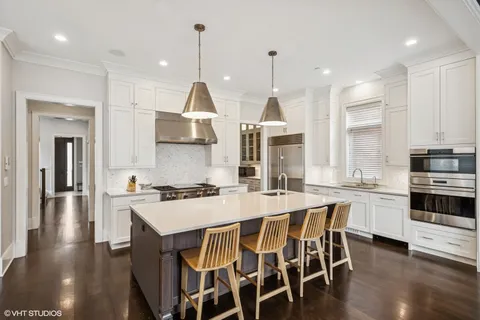 a kitchen with stainless steel appliances white cabinets and a stove top oven