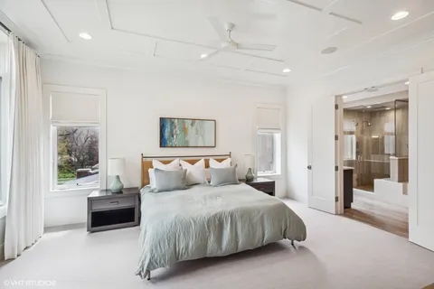 a spacious bedroom with a bed and a flat screen tv