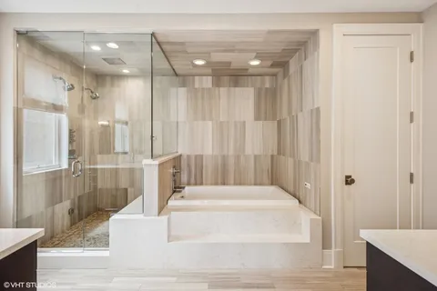 a bathroom with a sink vanity granite tub and a mirror