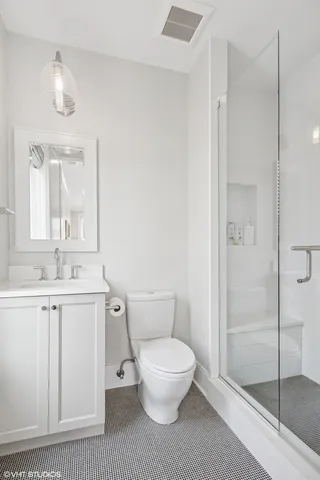 a kitchen with a refrigerator and white cabinets