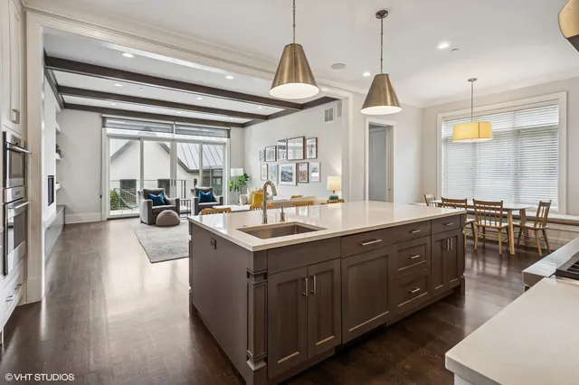 a kitchen with stainless steel appliances granite countertop a sink a stove and a wooden floors