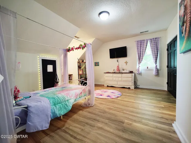a bedroom with a bed and a flat screen tv
