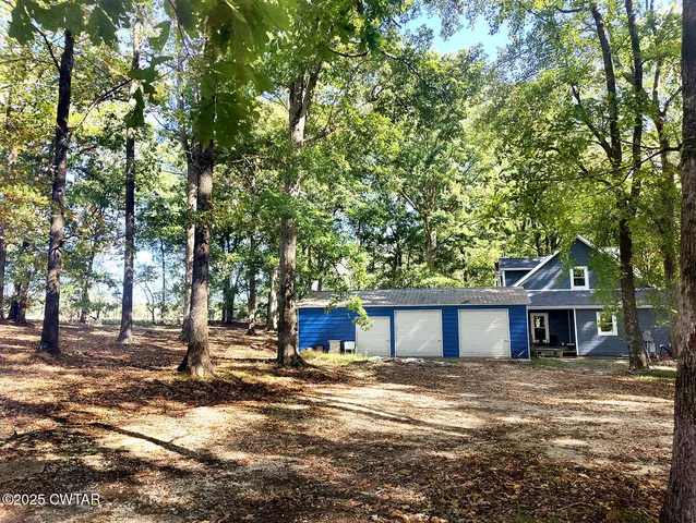 a front view of a house with a yard and trees