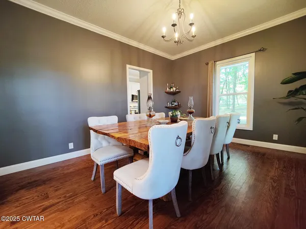 a view of a dining room with furniture wooden floor and chandelier