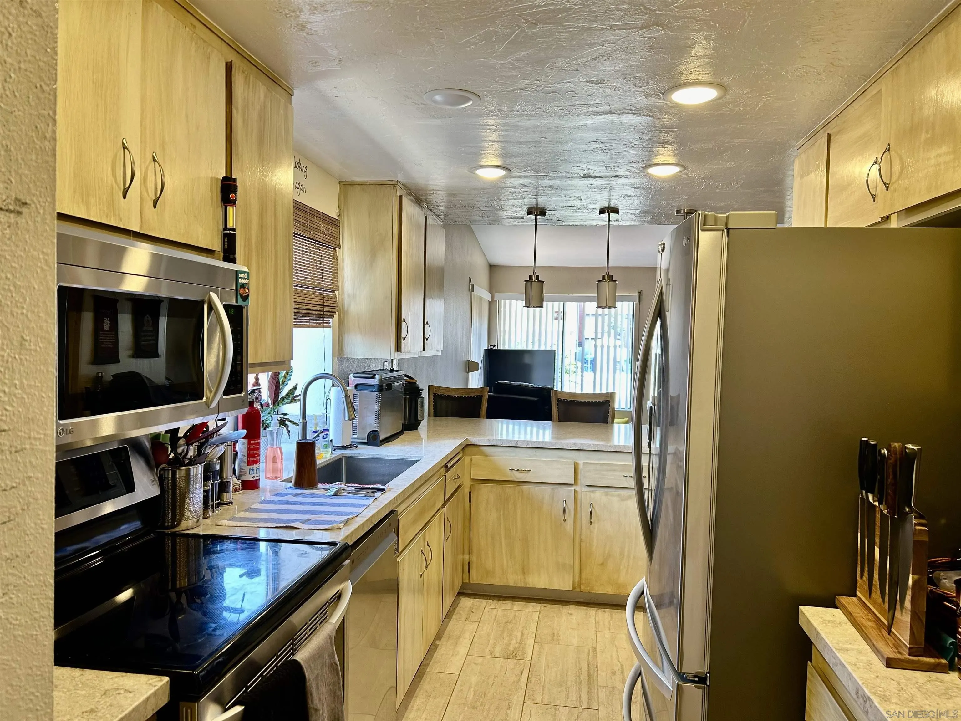 9627 Ramsgate Way Santee, CA 92071 - Photo 19 of 21 a kitchen with stainless steel appliances granite countertop a sink a stove and a refrigerator