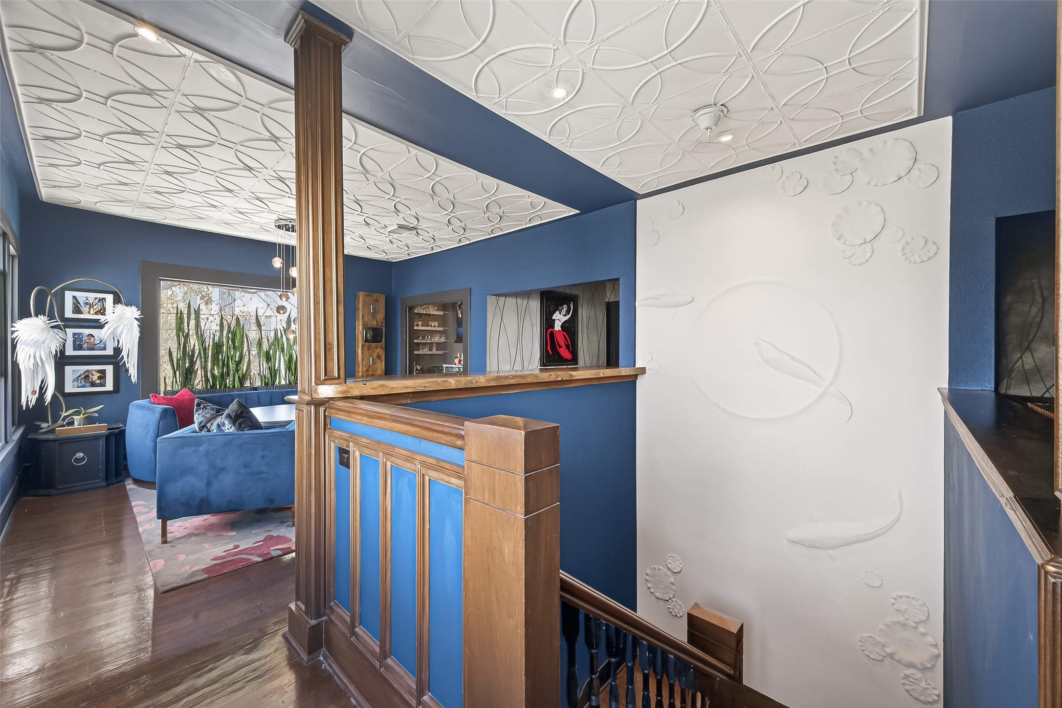 301 West Clay Street Houston, TX 77019 - Photo 6 of 24 Staircase connection to the first-floor entry, highlighted by a floating wall of custom art that showcases the property’s creative, artist-inspired space.