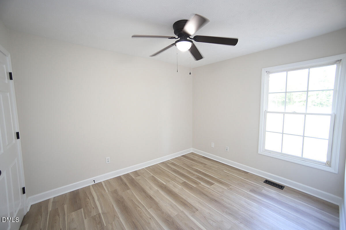 879 O B J Road Dunn, NC 28334 - Photo 13 of 23 wooden floor in an empty room with a window