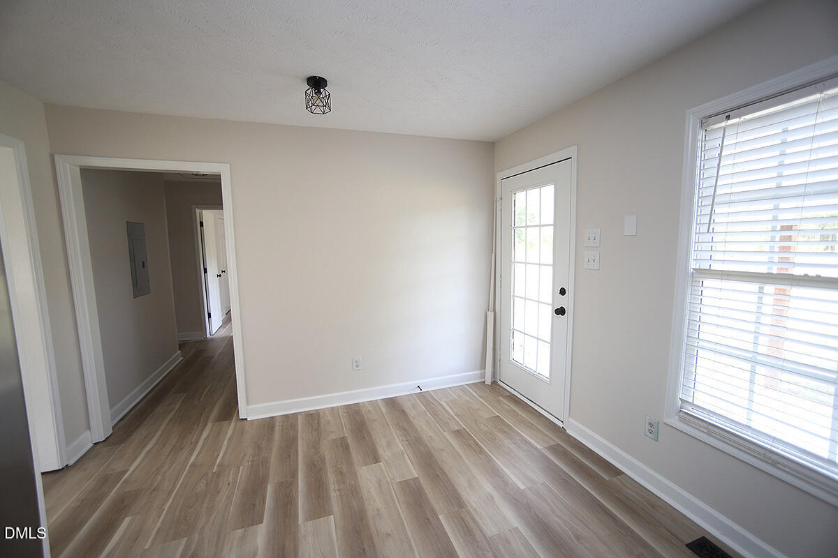 879 O B J Road Dunn, NC 28334 - Photo 16 of 23 a view of an empty room with wooden floor and a window