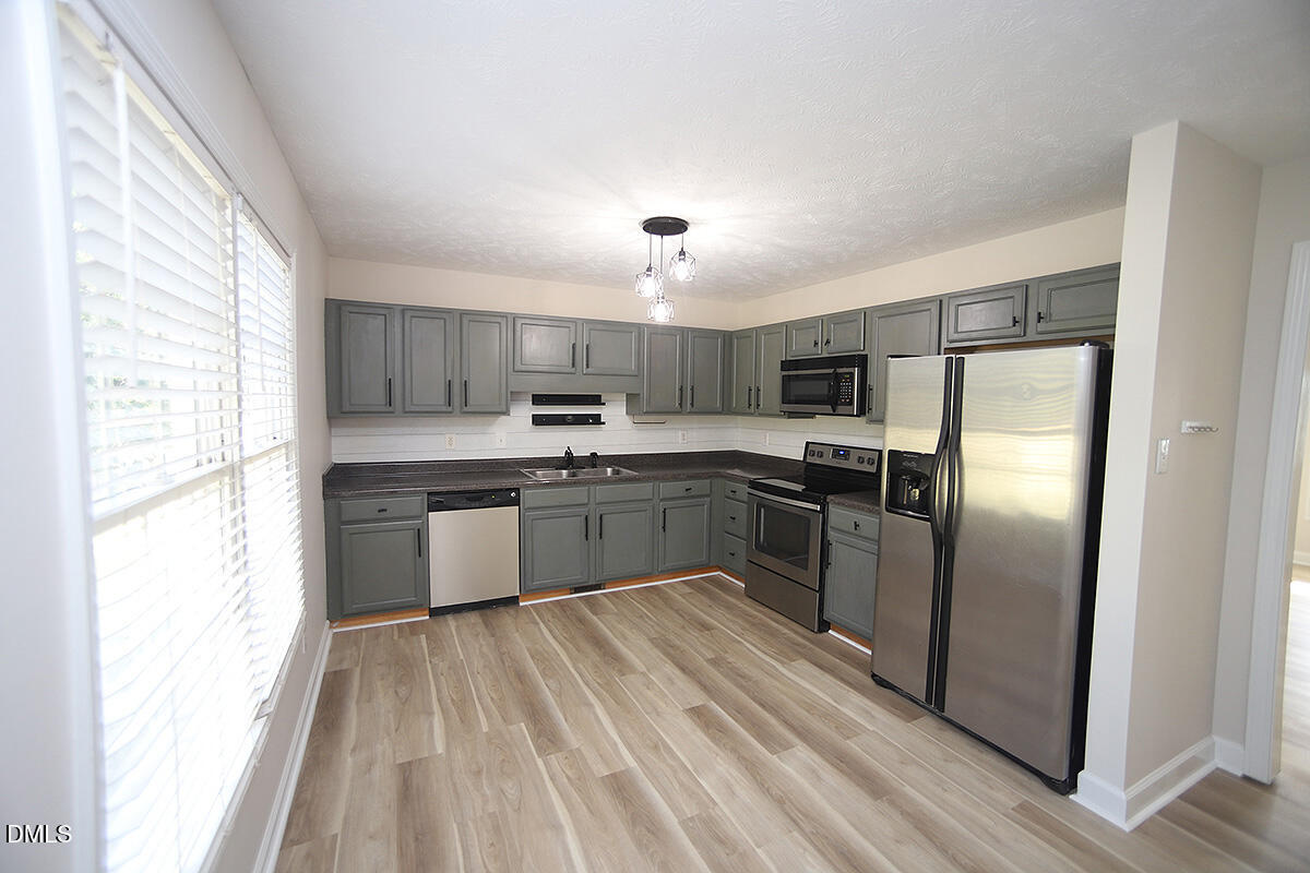879 O B J Road Dunn, NC 28334 - Photo 8 of 23 a kitchen with stainless steel appliances granite countertop a stove a sink dishwasher a refrigerator and a refrigerator