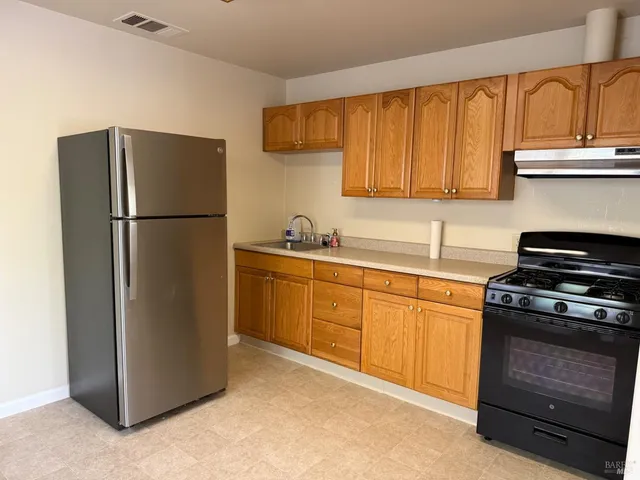 a kitchen with a refrigerator sink and stove top oven