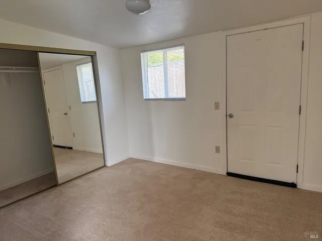an empty room with windows and closet