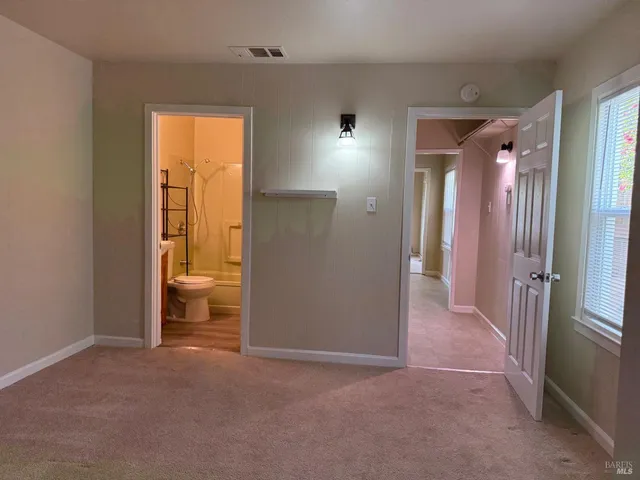 an empty room with a bathroom and a sink