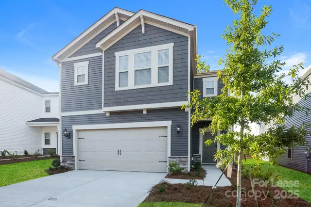 a front view of a house with a yard garage and outdoor seating