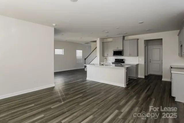 a kitchen with wooden floors and white stainless steel appliances