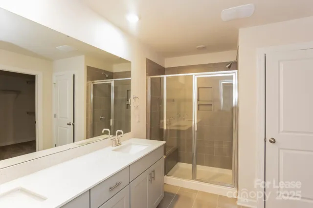 a bathroom with a shower sink and mirror