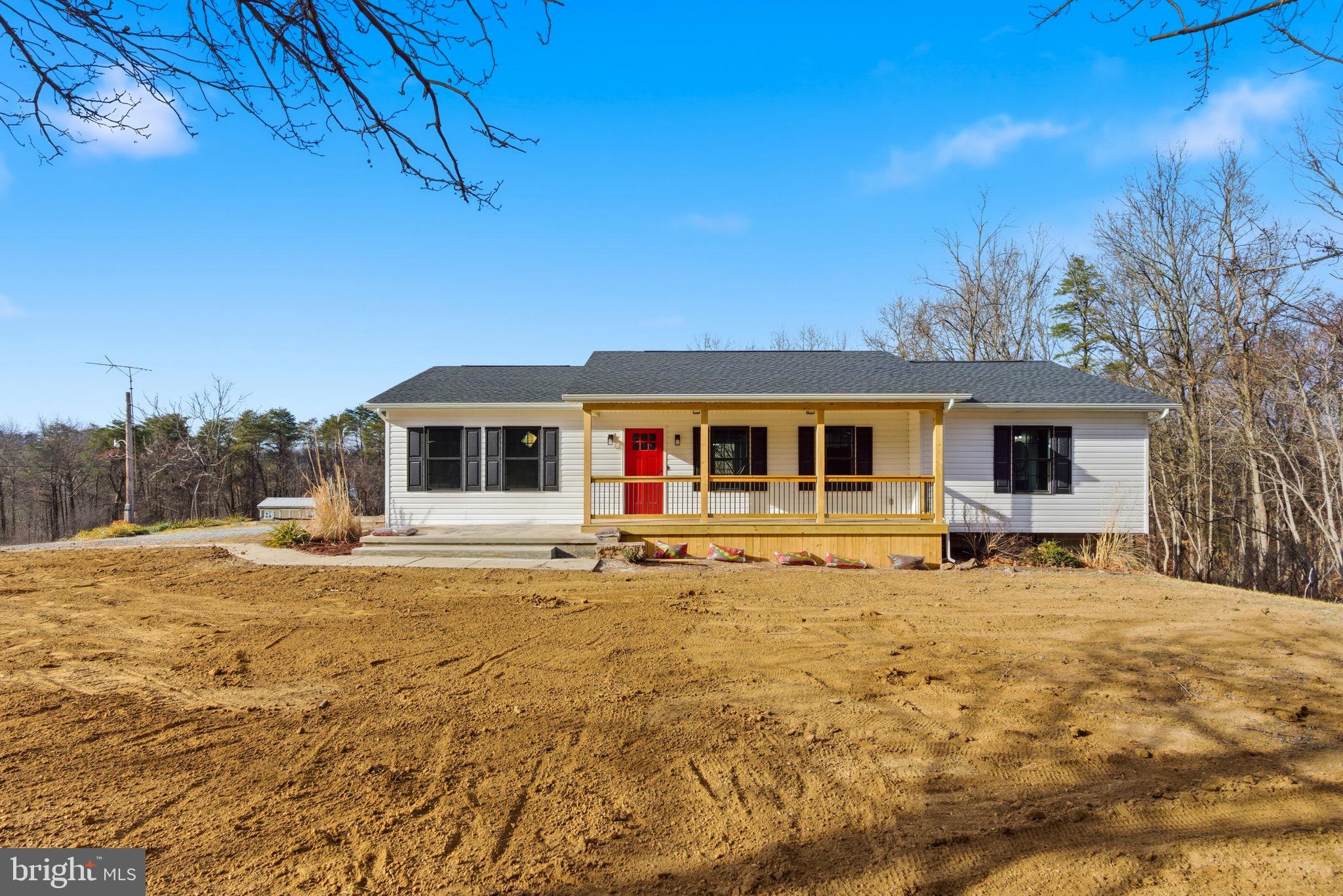 14 Anderson Court Berkeley Springs, WV 25411 - Photo 33 of 52 a backyard of a house with table and chairs under an umbrella
