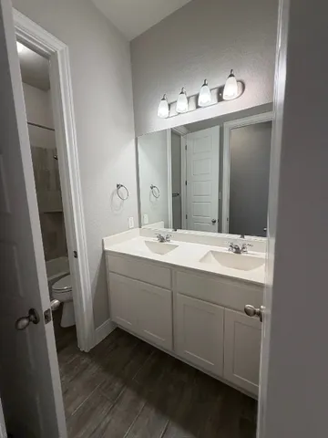 a bathroom with a double vanity sink and mirror
