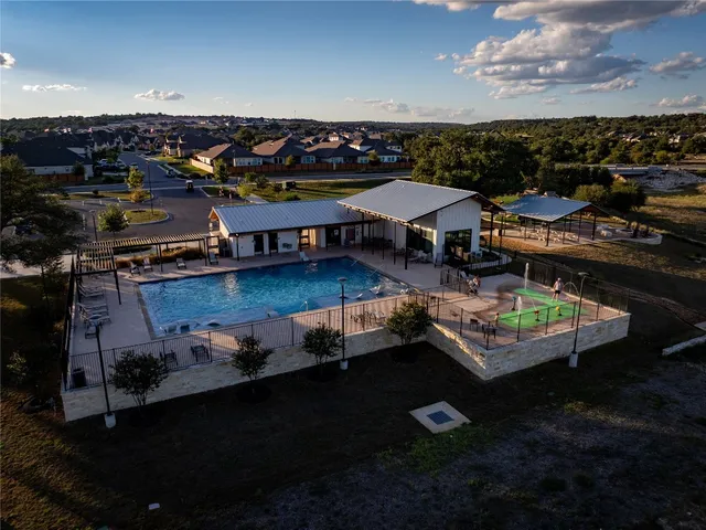 an aerial view of a house with swimming pool having outdoor seating