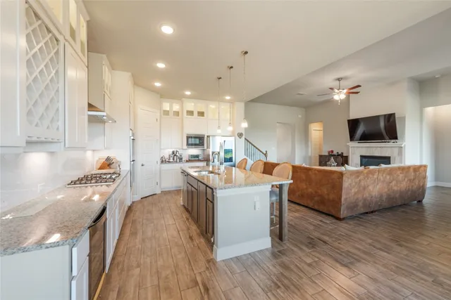 a living room with stainless steel appliances furniture and a flat screen tv
