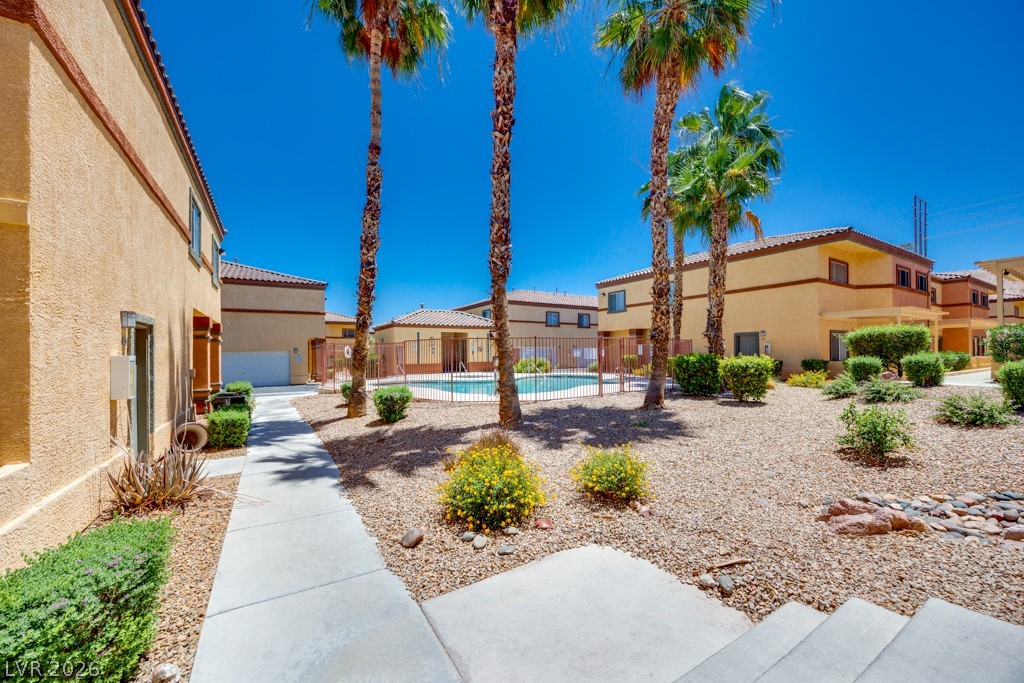 4915 East Russell Road, Unit 127 Las Vegas, NV 89120 - Photo 3 of 19 Lush palm trees surround a community pool, offering a refreshing desert oasis.