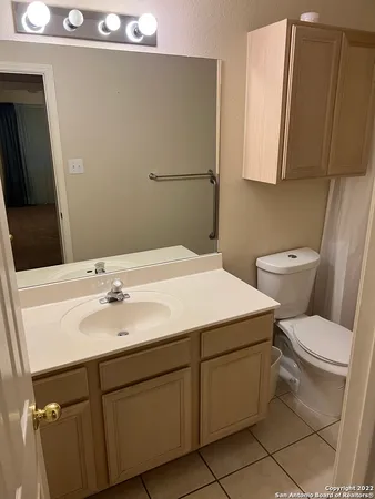 a bathroom with a toilet sink and mirror