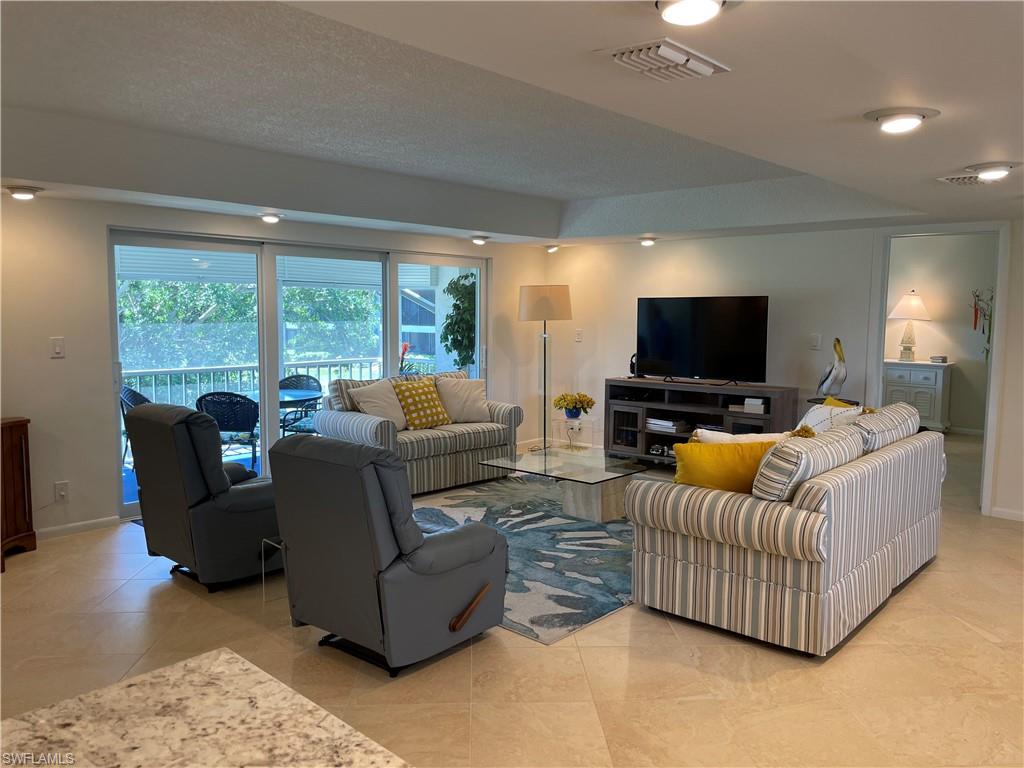 261 Quails Nest Road, Unit 6 Naples, FL 34112 - Photo 16 of 32 a living room with furniture and a flat screen tv