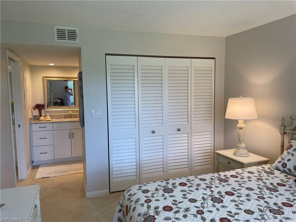 261 Quails Nest Road, Unit 6 Naples, FL 34112 - Photo 25 of 32 a bedroom with a bed and a lamp