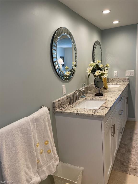261 Quails Nest Road, Unit 6 Naples, FL 34112 - Photo 28 of 32 a bathroom with a granite countertop double vanity and a mirror