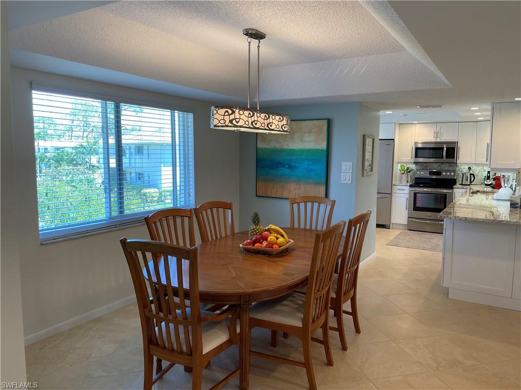 261 Quails Nest Road, Unit 6 Naples, FL 34112 - Photo 9 of 32 a dining room with furniture window wooden floor